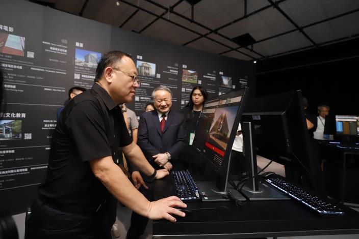 文化部長史哲（左）參觀2023臺灣文博會空總展區「打開空總_X_AI多重未來」，展覽運用AI演算，結合科技藝術，生成空總未來可能的樣貌與影像，啟發觀者的想像。