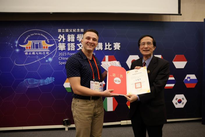 譚翔達（國立臺灣大學，美國籍），演說「AI對人類的影響」，榮獲第三名，並與陳彥豪評審委員合影