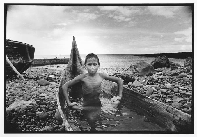 潘小俠，《蘭嶼記事》，〈坐在船上的小孩〉，1986，國家攝影文化中心典藏。潘小俠自1980年第一次踏上蘭嶼後，便與這個島嶼結下不解之緣，直至2022年再版《蘭嶼記事1980-2022：潘小俠影像》，共計拍攝了四十二年。