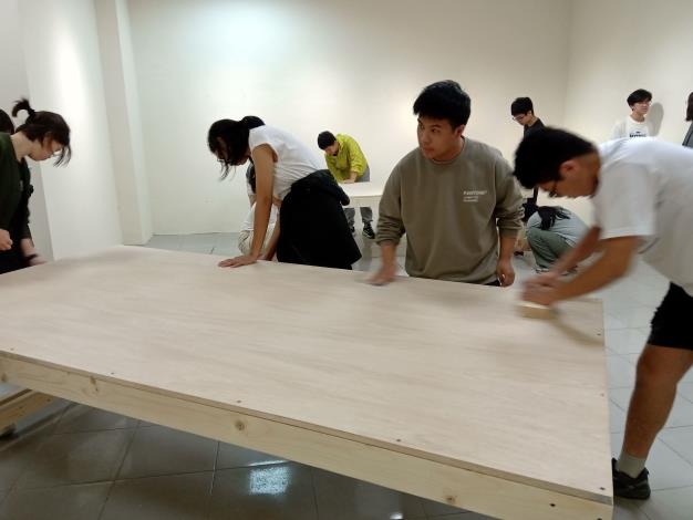 學員使用砂紙將工作桌表面及邊角磨平