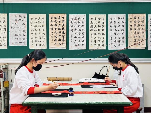 新竹市建華國中八年級美術班的李沂瑾、李妍潔同學專注於書寫春聯