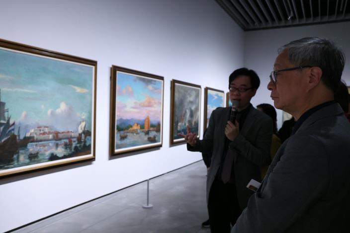 文化部長李遠（右）參觀「福爾摩沙時代—臺灣近現代美術的知識啟蒙」展覽，策展人白適銘（左）導覽小早川篤四郎創作的〈臺灣歷史畫帖〉系列作品。