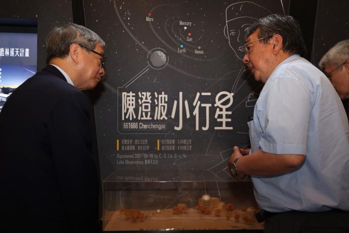 國立中央大學天文研究所長周翊（右）藉「陳澄波小行星微型展」中的鹿林天文臺模型，向文化部長李遠（左）說明其運作情況。
