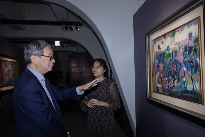 策展人國立成功大學藝術研究所長吳奕芳（右）為文化部長李遠（左）導覽「玩色‧巧師：臺灣戰後第一代女性藝術家鍾桂英」，介紹鍾桂英於1992年創作的〈林〉。