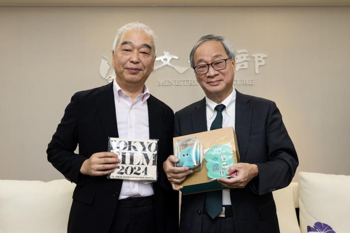 Minister Li Yuan (right) exchanges gifts with Tokyo Film Festival senior programmer Kenji Ishizaka (left)