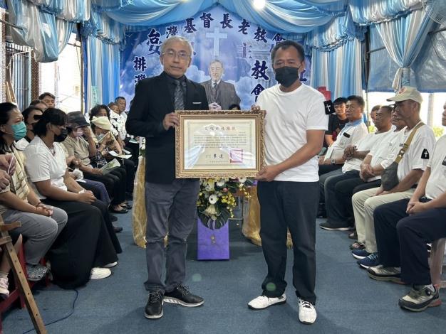 Chen Chi-min (left), director general of the Bureau of Cultural Heritage, presents a posthumous certificate, which is received by the Secilu Isausau’s son Chen Yao-tsu (right)