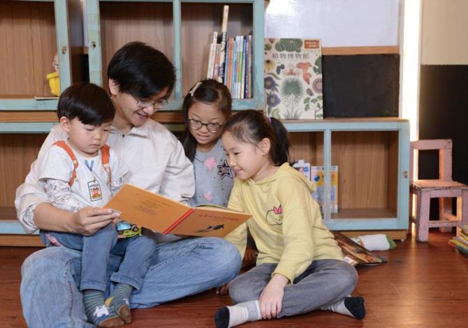 Founder Yeh Chia-hao and children reading a book