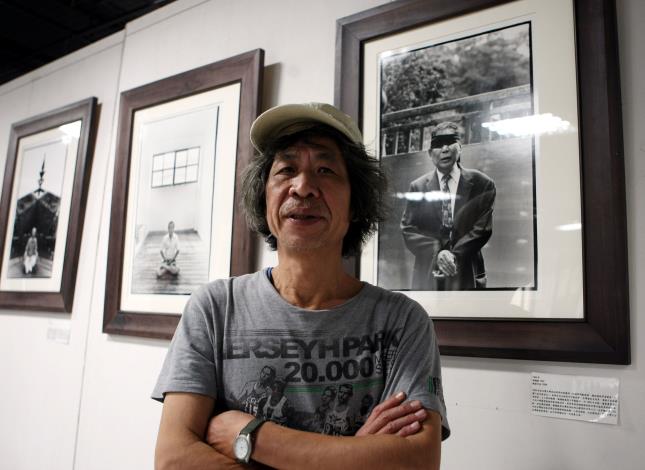 Pan Hsiao-hsia standing before his works
