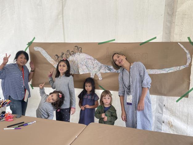林小杯在多倫多國際作家節兒童繪畫活動中，帶領小朋友合作完成巨大恐龍圖畫