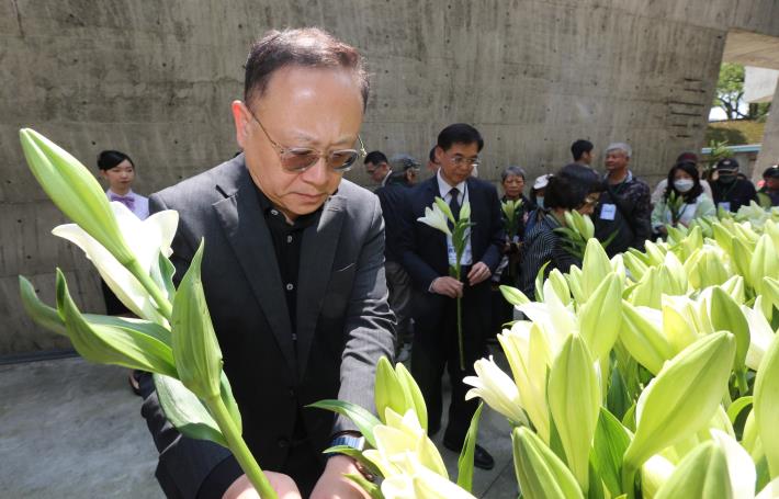 Menteri Kebudayaan Shih Che (kiri) mempersembahkan bunga di depan monumen peringatan HAM