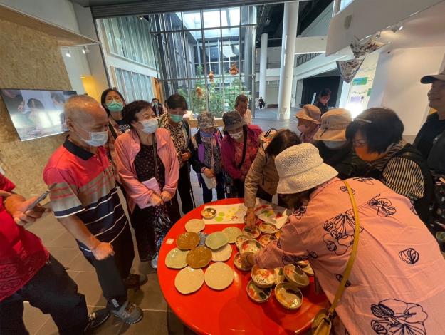 2_員榮醫院醫事Ｃ據點長者到展場觀賞自己的作品展出，立即擁簇而上熱烈討論。圖片由國立臺灣美術館提供。