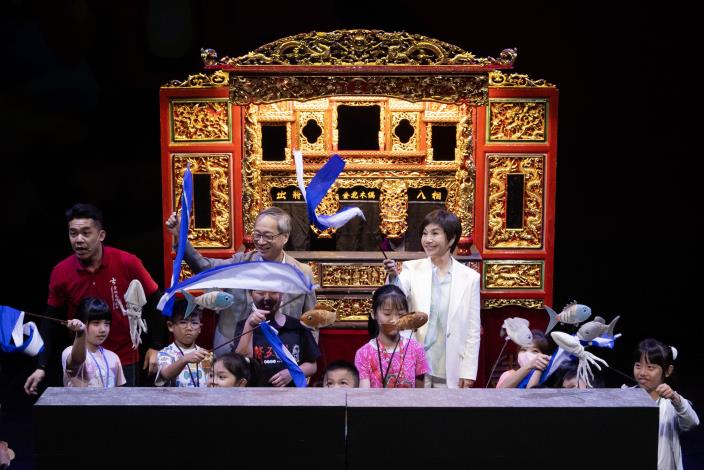 臺北木偶劇團演出《燈猴》精彩片段，並邀請文化部長李遠（後中）、唐美雲歌仔戲團長唐美雲（後右）一起與小朋友們化身海浪及魚，體驗角色配合音樂及劇情編排而有不同的詮釋方
