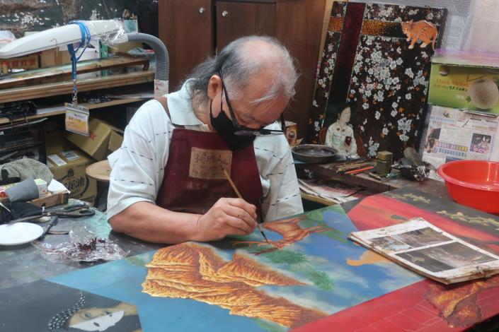 王清源工藝師專注創作的模樣，吸引遊客駐足欣賞。