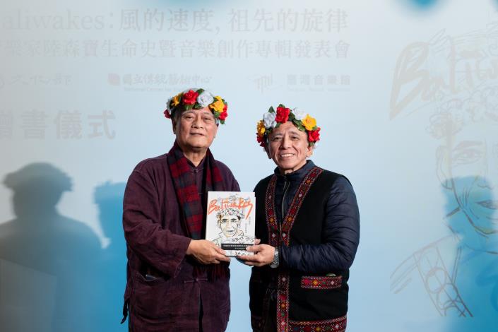 發表會中由作者孫大川(左)致贈專書予陸森寶公子陸賢文(右)。