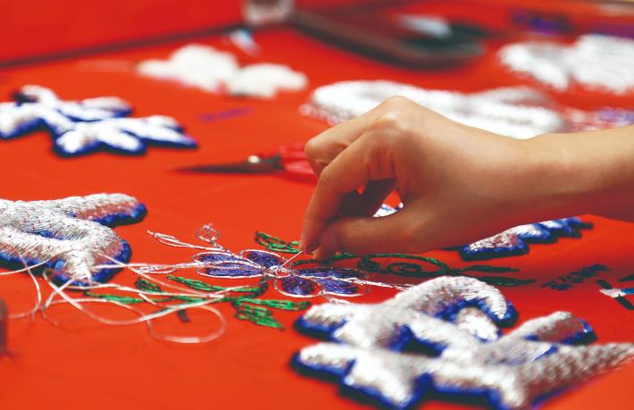 運用色彩繽紛的蔥線為繡品上色，細膩技法讓繡品更耀眼。（楊為仁攝）