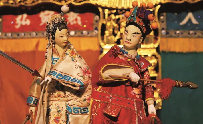 弘宛然《虹霓關》角色王伯當（紅衣）與東方氏（白衣），透過身段節奏與色彩配置，形塑角色關係的動態平衡。（弘宛然古典布袋戲團提供）