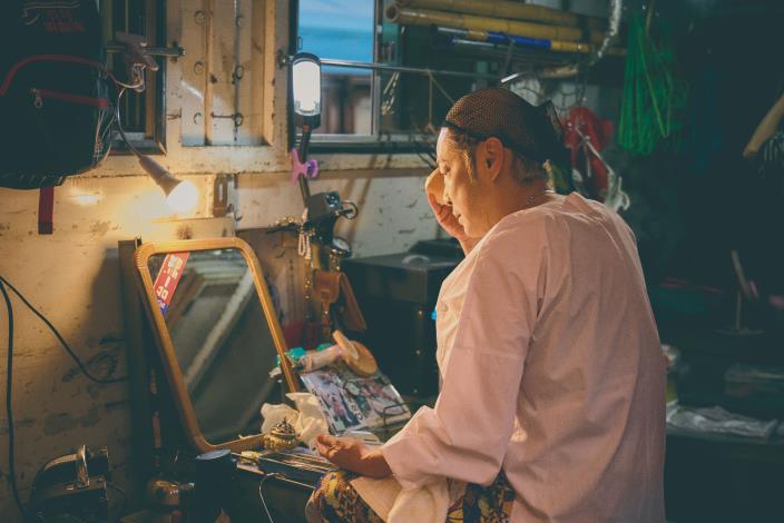 秀琴一到野臺現場，在車內立即上妝、戴頭套、換裝伸展，凡事自己來。（張智傑攝）