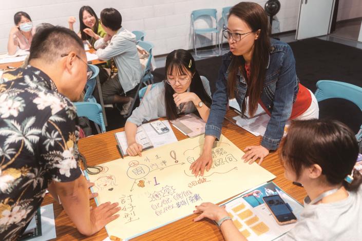 「偶．有戲」2024兒童布袋戲劇本創作研習營，由陳崇民老師(左)輔導學員分組討論劇本大綱。（國立傳統藝術中心提供）