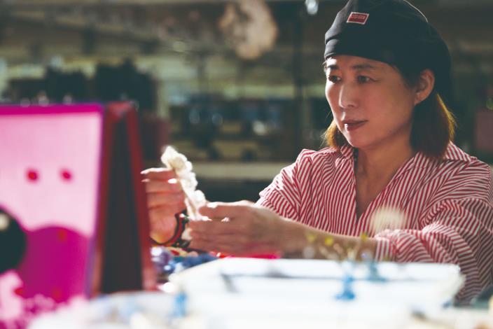 朵朵絹花在邢源琳的指尖微微轉動，屏息凝神地將這抹柔色調整到恰到好處。那不僅是飾品的色彩與位置，更是角色整體造型的的平衡與氣韻。（張智傑攝）