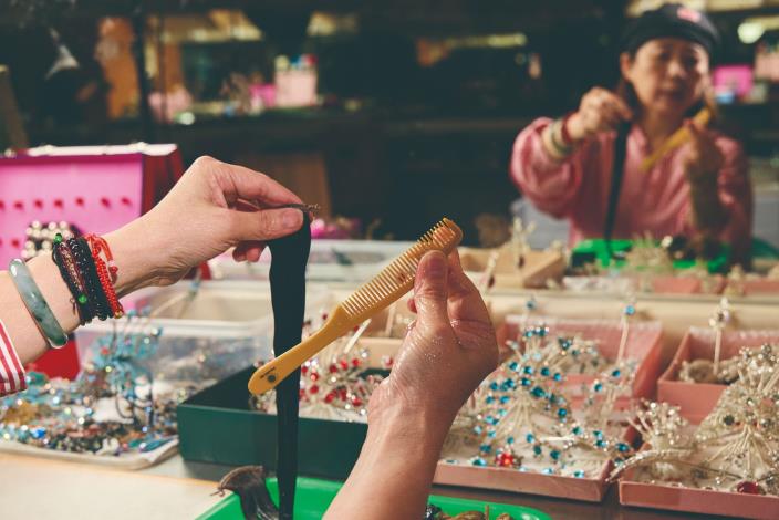 在旦角造型的梳化過程中，邢源琳取用刨花黏液梳理髮絲，再進行「打片子」；以整齊髮片塑形、捲曲、定型，最後將片子貼合於雲鬢之間，層層堆疊、絲絲服貼，構築起典雅端莊的旦角髮型。（張智傑攝）