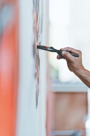 陳冠良總說謝謝大家「嘸棄嫌」，此時他正聚精會神繪製新藝芳歌劇團布景牌樓。（陳冠良提供）