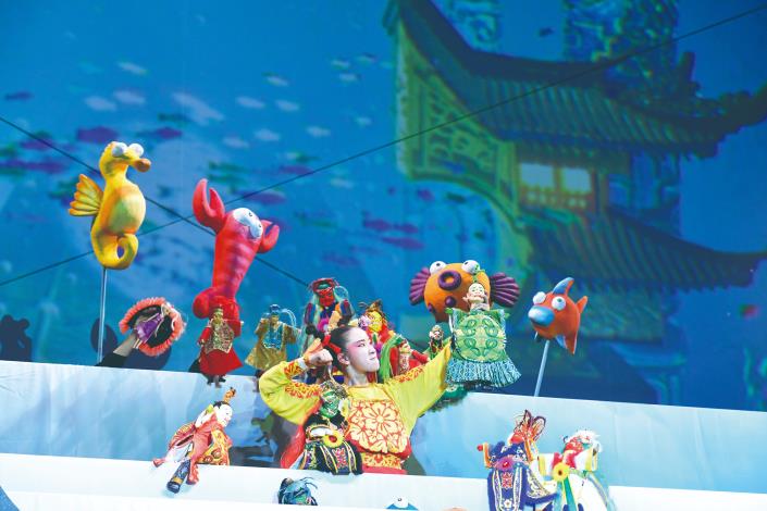 在《哪吒鬧龍宮》的舞臺上，真人演員與戲偶同臺演出，傳統戲曲身段與現代舞臺科技交織，打造跨越神話與現實的奇幻龍宮世界。（紙風車劇團提供）