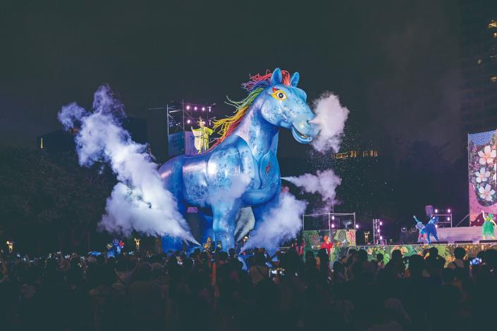 結合歌舞、特技與數位特效，身披繁花的雨馬能行走、會眨眼、張嘴還會噴氣。為了親眼目睹這匹全臺最大的行動藝術，大家都要找個好位置拍照，真的都拚了！（紙風車劇團提供）