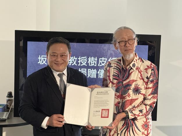 日本紙質文化資產保存與搶救專家坂本勇（SAKAMOTO Isamu）教授(右)無償捐贈珍稀樹皮紙／布文物等45件文物予國立臺灣史前文化博物館，由蔡政良館長(左)代表接受並致贈感謝狀