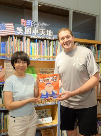 「美國小天地」為臺文館與美國在台協會高雄分處11年的合作成果，臺文館長林巾力（左）、美國在台協會高雄分處長張子霖（右）手持繪本𝑶𝒍𝒚𝒎𝒑𝒊𝒈合影。