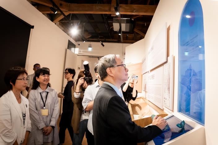 文化部長李遠於「臺灣與世界：以文學對望」展覽中操作阿美族口傳故事的互動裝置。