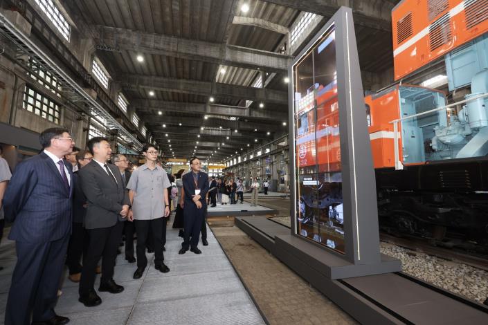 行政院長卓榮泰（左1）參觀「柴電劇場：柴電機車的運作」，巨型滑軌螢幕宛如電腦斷層掃描般，呈現柴電機車部件及作動原理。