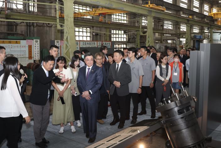 國家鐵道博物館籌備處主任鄭銘彰（前左2）向行政院長卓榮泰（前左3）導覽常設展「動力．火車－柴電工場」，介紹平常難以窺見、柴電機車內部的重要部件。