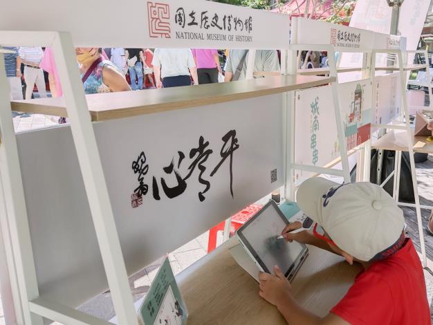 史博館開發運用平板APP與觸控筆，可親筆臨摹體驗三件館藏書法作品的「行動寫字檯」，歡迎民眾來市集體驗。