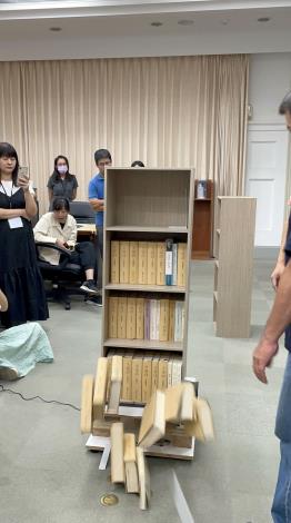Participants test the reaction of books falling from each shelf of a bookcase under an intensity 6+ earthquake (based on the Central Weather Administration seismic intensity scale, CWASIS) using an earthquake simulator.