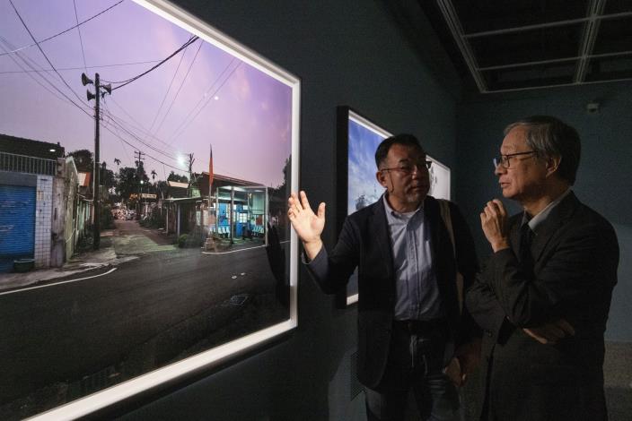 臺灣參展藝術家沈昭良（左）向文化部長李遠介紹《漂流》系列作品，並說明當時拍攝的觀察與情境。