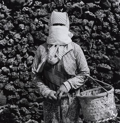 《澎湖印記》09︰〈蒙面女〉 2004年，湖西青螺。 咾咕石是澎湖人對珊瑚礁石灰岩的稱呼，為早期澎湖人常用的傳統建築材料。澎湖地勢平坦，無高山阻擋，因而風大日烈。早期澎湖婦女多半會在農閒時打零工補貼家計。婦女外出勞動時，會以布巾蒙面，藉以遮日擋風，成為澎湖婦女的特殊文化。咾咕石則是常用來築牆擋風，保護家戶菜園裡的作物，稱之為「菜宅」。菜宅有時亦會使用澎湖常見的玄武岩搭建。