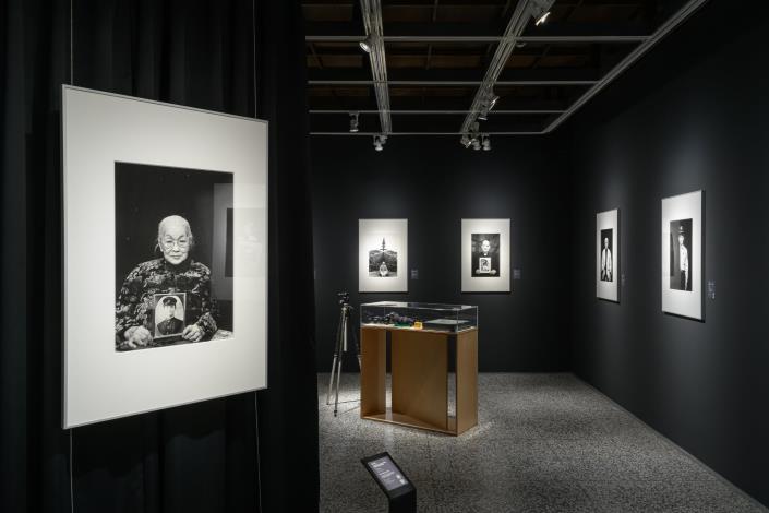 〈藍張阿冬與先生藍明谷〉作品中，攝影家潘小俠安排藍張阿冬手持藍明谷青年時期肖像照，以樸實的燈光，黑布為背景，讓主體明亮，視覺集中於被攝者的神情與手中的肖像，形成觀者無可閃躲的凝視。此手法同時避免被攝者所處環境不適合拍攝，反映潘小俠對被攝者及政治受難者的尊敬。 作品資訊： 潘小俠〈白色烙印1949~2009人權影像：藍張阿冬與先生藍明谷〉，2009，明膠銀鹽相紙，60.9 × 50.5 cm公分，國家攝影文化中心典藏 攝影：王世邦