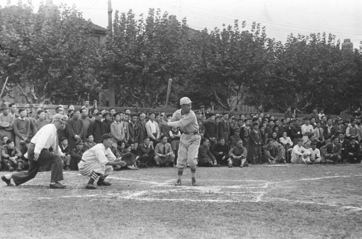 攝影家吳紹同作品，1947年。1945年到1960年代之間，臺灣棒球運動熱絡，此時期有許多棒球隊伍成立，如石炭隊、臺電隊、合庫棒球隊、糖廠棒球隊、鐵路局棒球隊、鐵路局棒球隊、臺灣省菸酒公賣局棒球隊、大涼隊、天香味寶隊、三軍棒球隊等。其中，石炭隊是全臺最強的球隊，當年只要是北市對外的比賽幾乎都由石炭隊代表。此張照片呈現石炭隊與上海震東隊友誼賽的比賽現場。