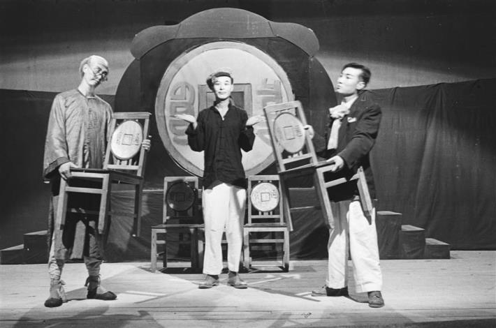 《財狂》劇照，左一為吝嗇鬼韓伯康（李影飾演），右邊為其子（張方霞飾演），這張照片幽默呈現兩人之間在感情與財務上針鋒相對的情況。
