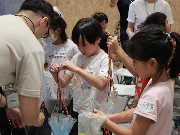在傘面對稱位置固定好每一條線、打結，確保降落傘能穩穩降落。