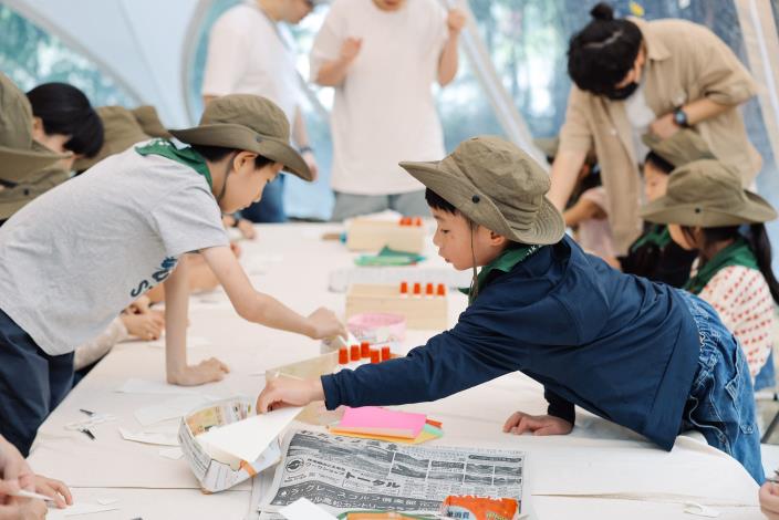 4 孩子專注操作著自己創作的紙偶