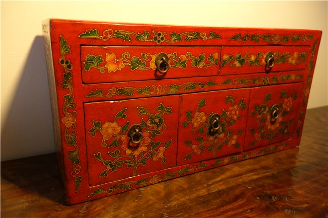 客廳老木桌上的紅櫃子，是吳建緯第一件購買的家具。