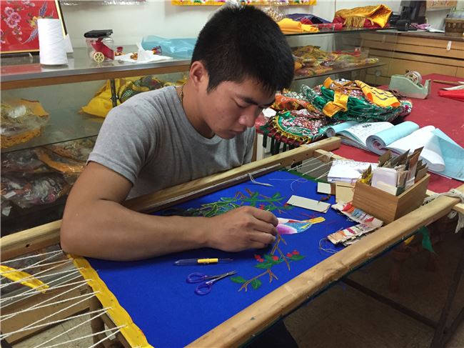 前來拜師學藝的21歲大男生蔡宏彬，才一個月就能將花鳥圖繡得栩栩如生