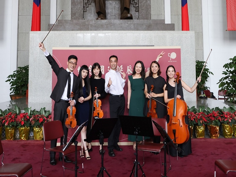 國父紀念館王蘭生館長（中）與共嗚室內樂團團員、演唱者劉格帆小姐（右3）、演唱者葉茲珽小姐（左2）合影。