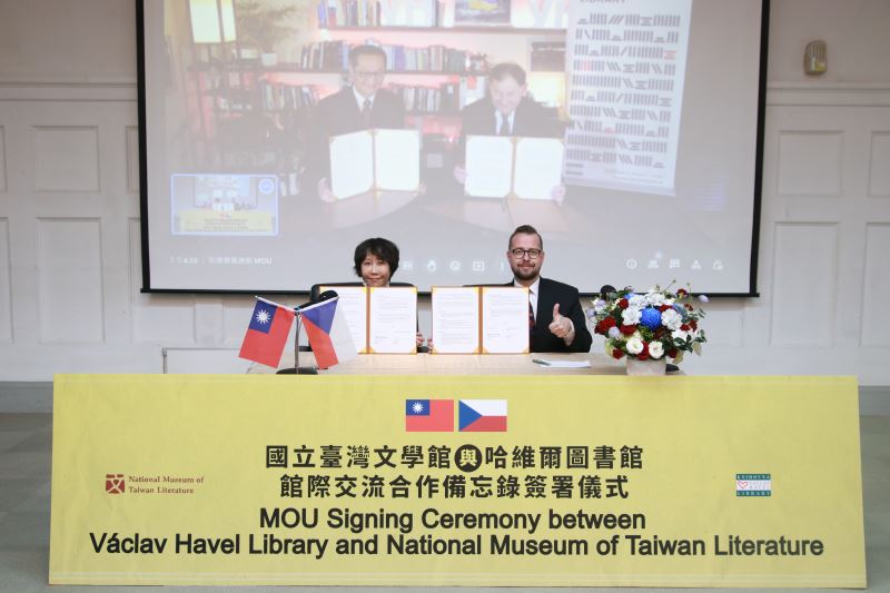 哈維爾圖書館館長麥可．贊托夫斯基（Michael Žantovský）（螢幕右）及臺文館館長林巾力（前排左）簽署象徵兩館友好之備忘錄