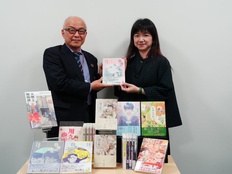 Lee Ching-hwi (right) presents a Taiwanese comic to Kitakyushu Manga Museum