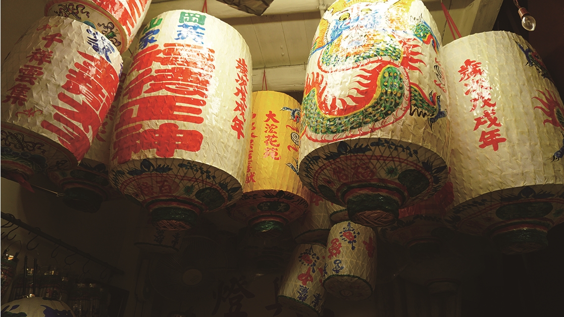 森興燈籠店裡滿室的手作燈籠，寫有來自各地宮廟的名稱與供奉的神尊聖名。